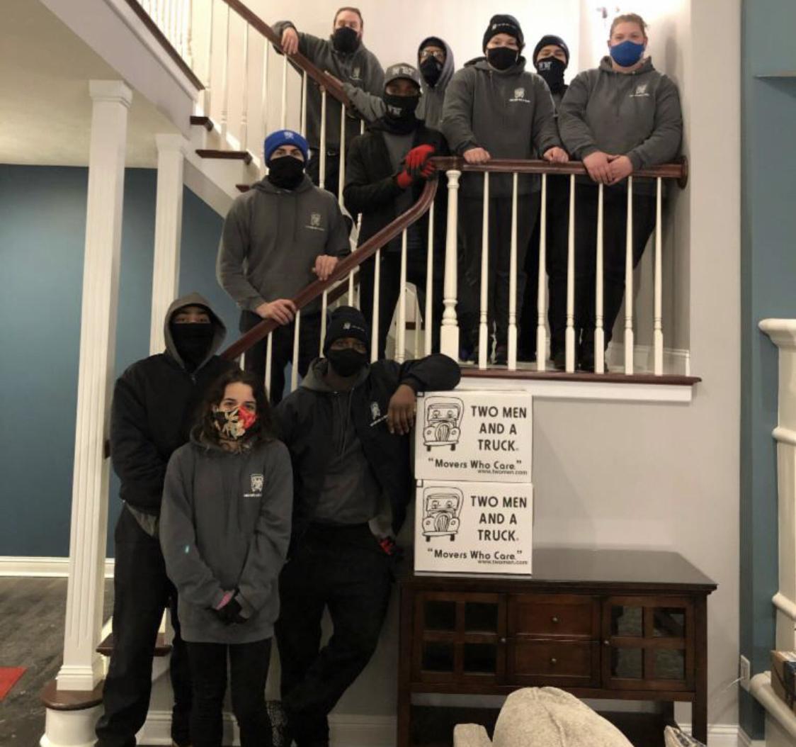 Large Group Shot of Movers and Drivers standing on stairs in a customer&#039;s home