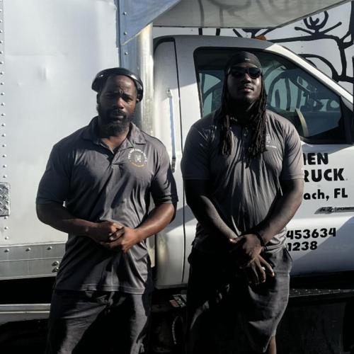 Berry and JHarris standing in front of a moving truck