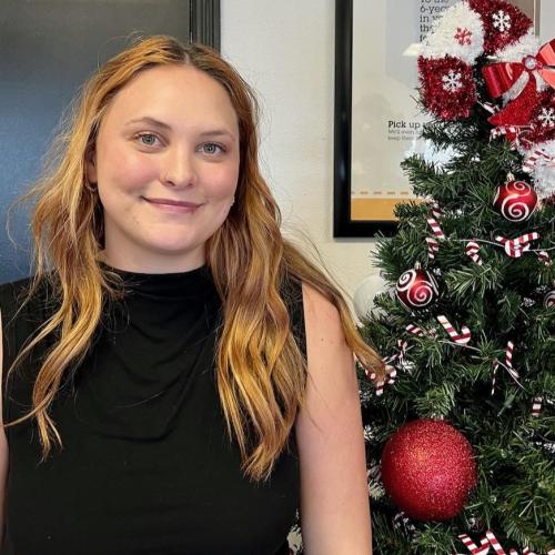 chloe standing next to a Christmas tree