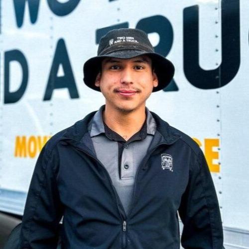 danny is standing in front of a moving truck outside