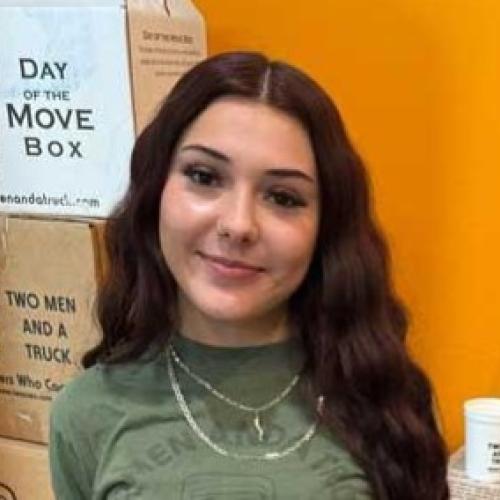 employee pictured in front of moving boxes