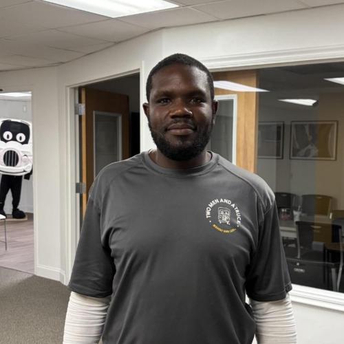 picture of cornell in the office with truckie the mascot in the background photo bombing
