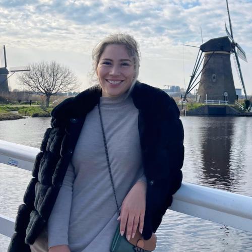 Karen H - move consultant with two men and a truck standing in front of a scenic lake with a windmill in the background