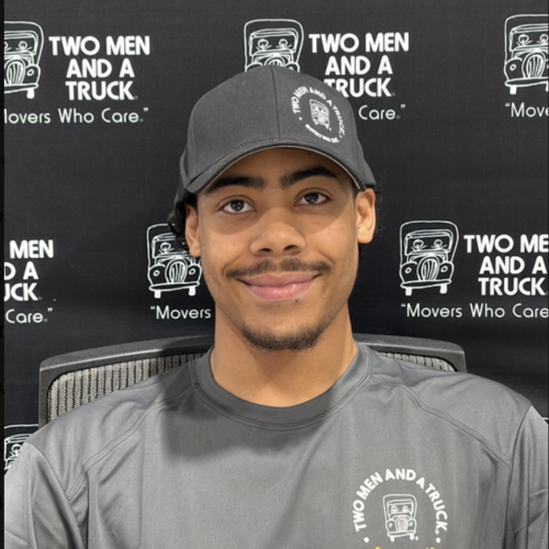 man in Two men and a Truck uniform standing in front of branded background