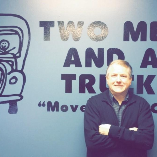 Rich H standing in front of company logo