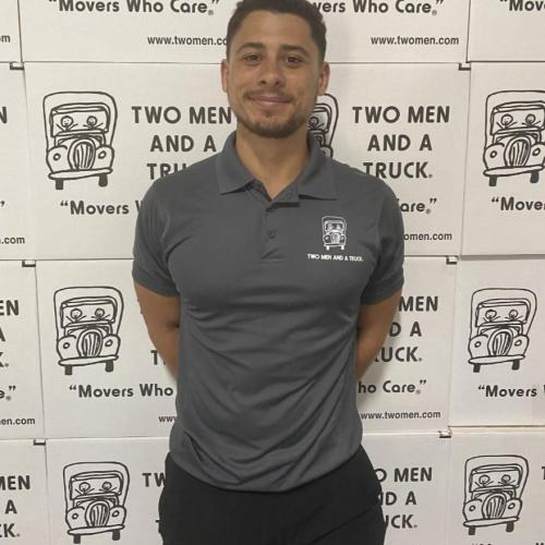 man smiling in front of a two men and a truck photo backdrop