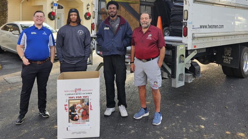 4 guys with a toys for tots box and a truck
