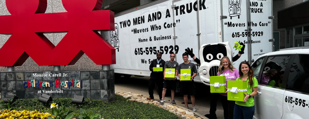 Photo of Two Men And A Truck Staff, with Cheeriodicals Staff in frot of Monroe Carell Jr. Childrens Hospital