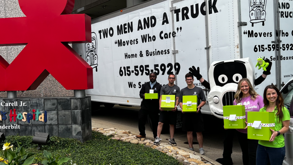 Photo of Two Men And A Truck Staff, with Cheeriodicals Staff in frot of Monroe Carell Jr. Childrens Hospital