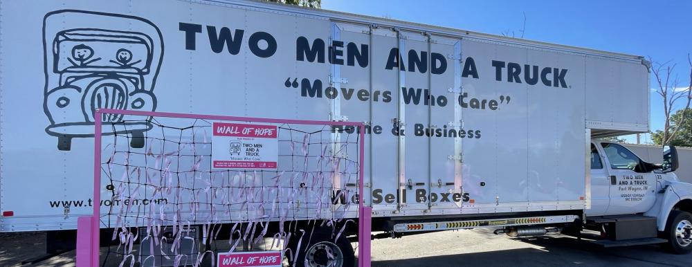 Wall of Hope with pink ribbons and Two Men and A Truck moving truck.