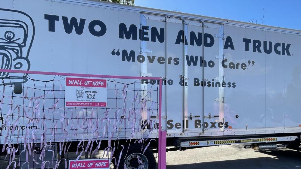 Wall of Hope with pink ribbons and Two Men and A Truck moving truck.