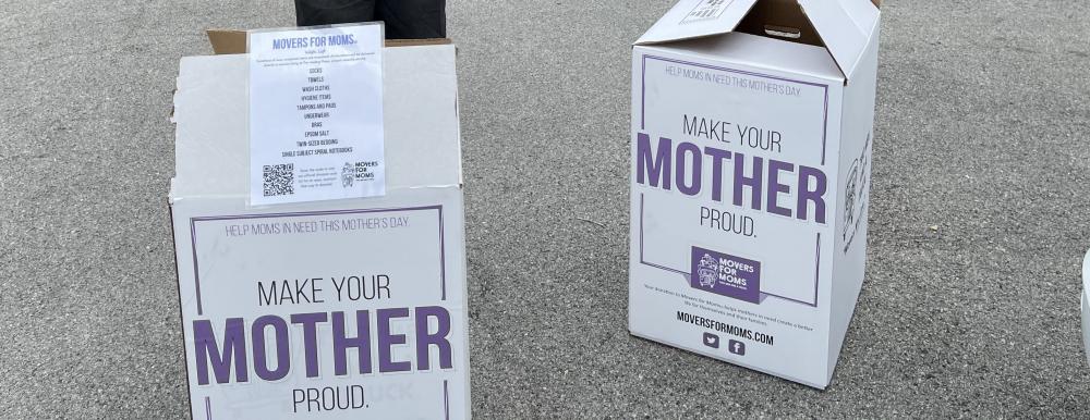 Movers for Moms labeled boxes sitting on pavement