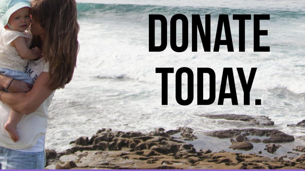A mother holding her child with the words "donate today" in the foreground