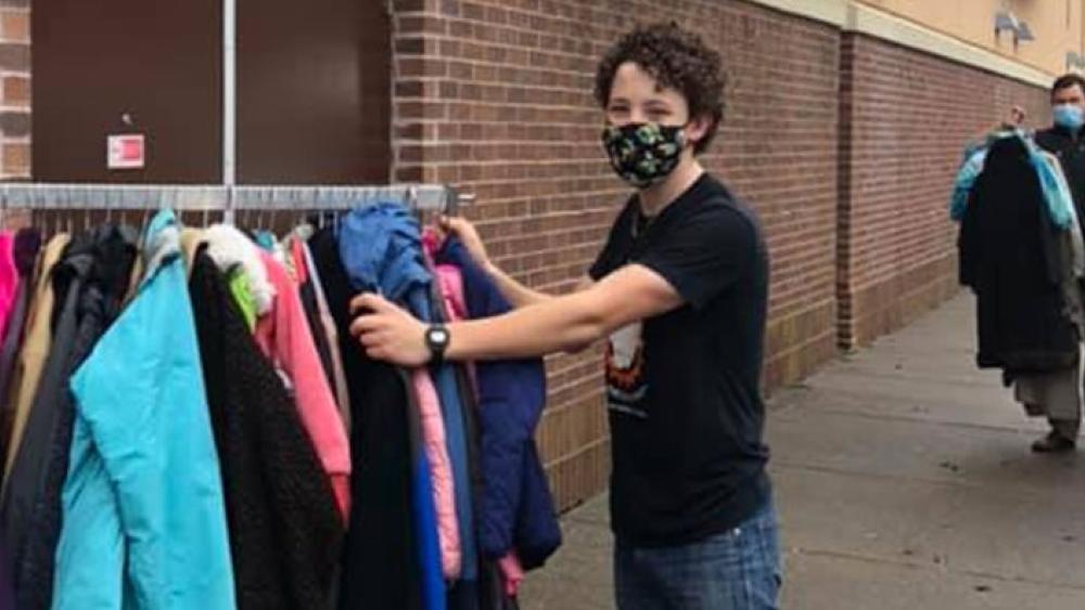 volunteer standing next to a coat rack