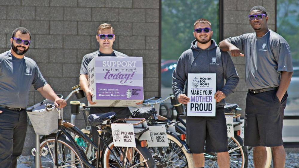 movers holding "Movers for Moms" boxes