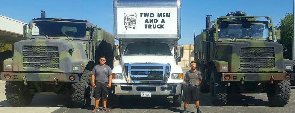 movers standing next to military trucks