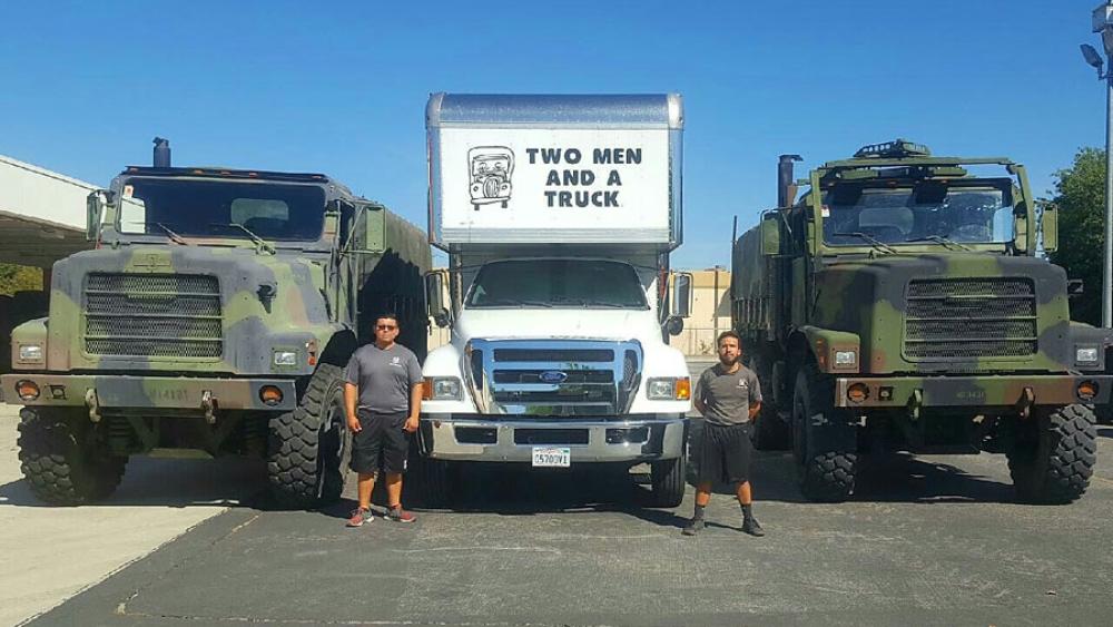 movers standing next to military trucks