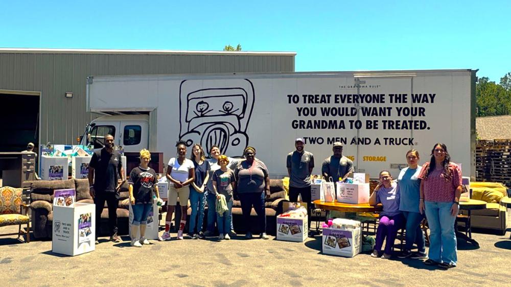 the team standing in front of a truck with volunteers and donated items