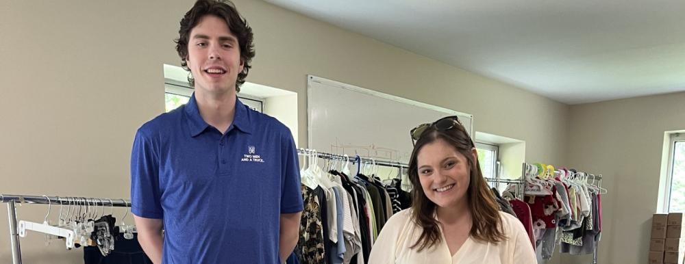 Movers for Moms collection drive with two people standing in front of donated items 
