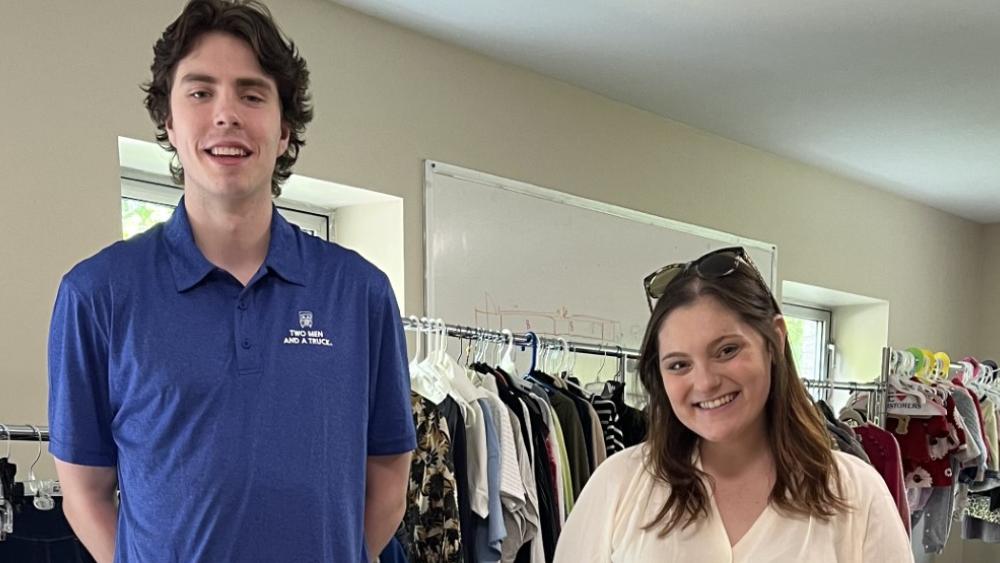 Movers for Moms collection drive with two people standing in front of donated items