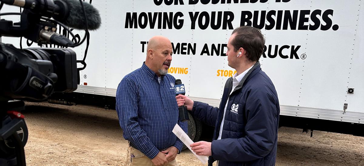Owner Terry being interviewed standing in front of a moving truck