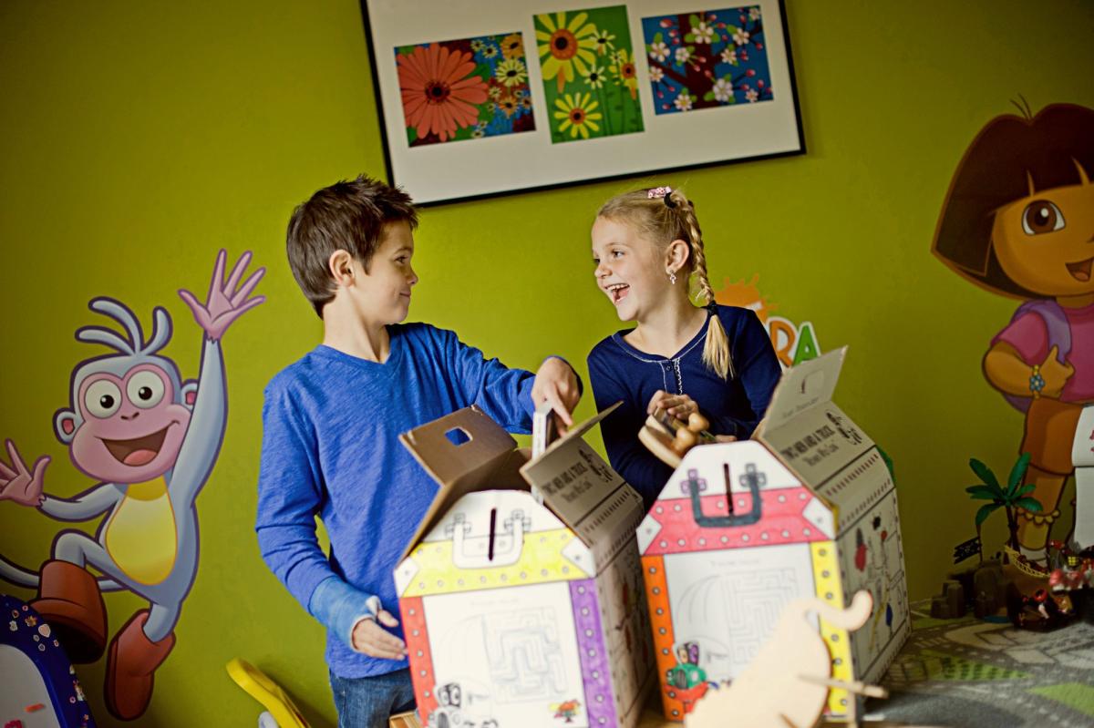 kids in bedroom holding two men and a truck craft boxes