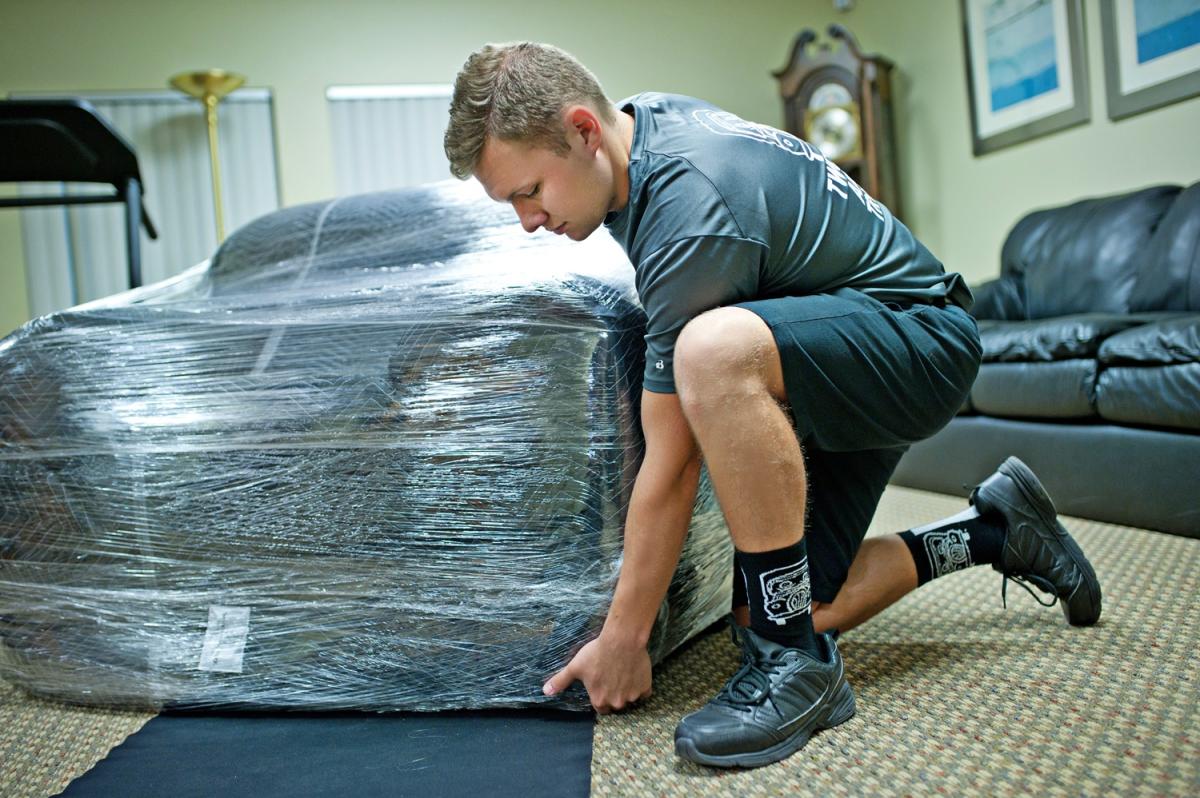 TWO MEN AND A TRUCK Mover Moving A Piece Of Furniture 