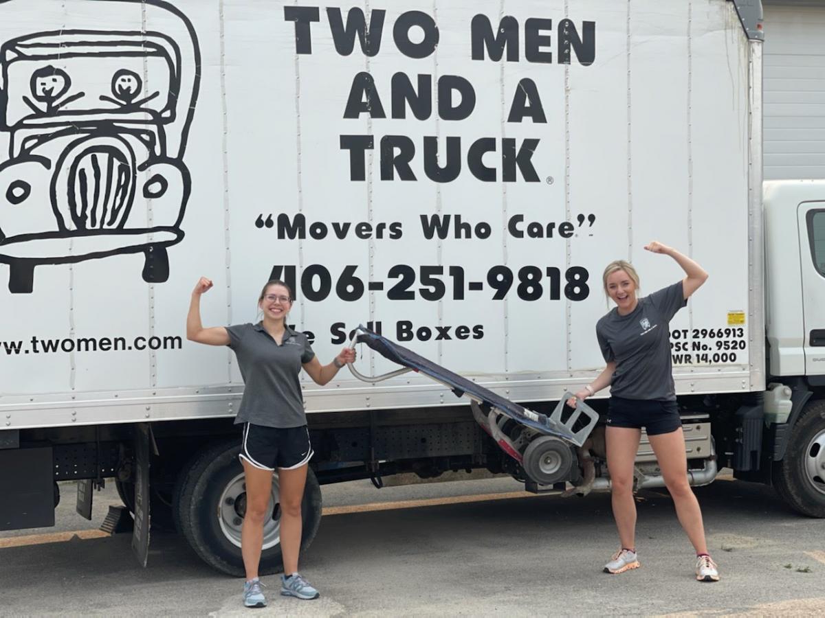 Giselle and Joslyn in front of two men and a truck truck 