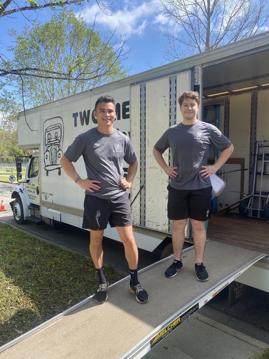 Two movers standing on a truck ramp