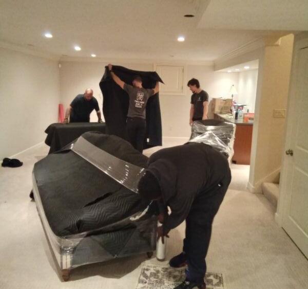 Moving crew padding furniture inside an apartment