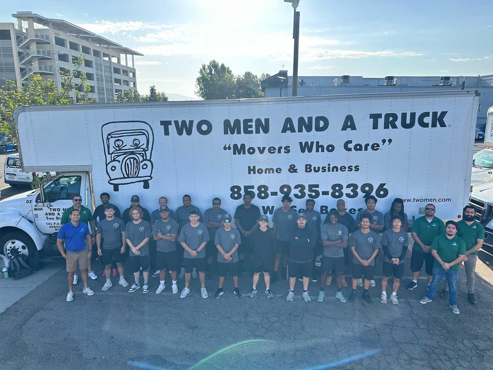 the whole team standing in front of a truck