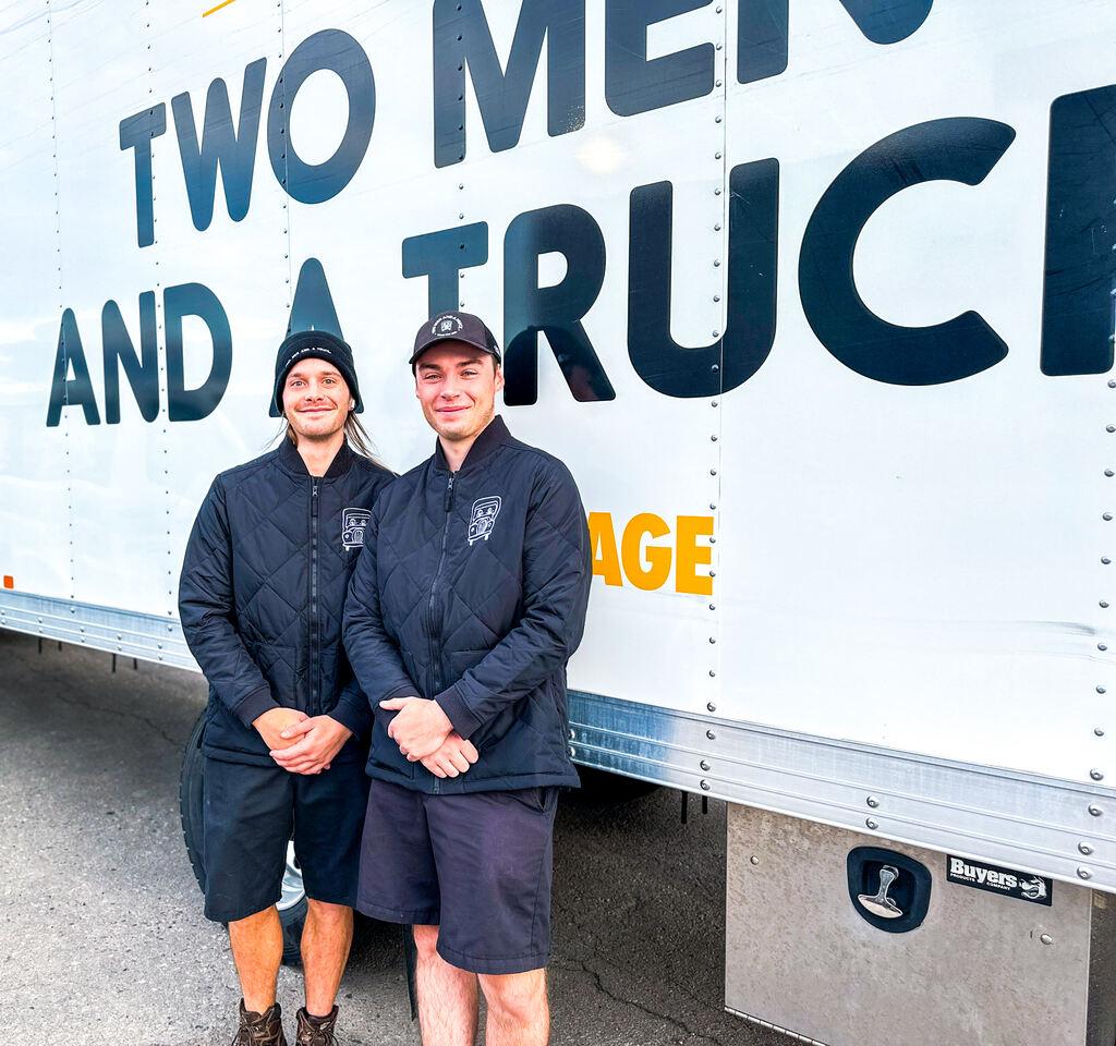 two movers standing in front of a truck