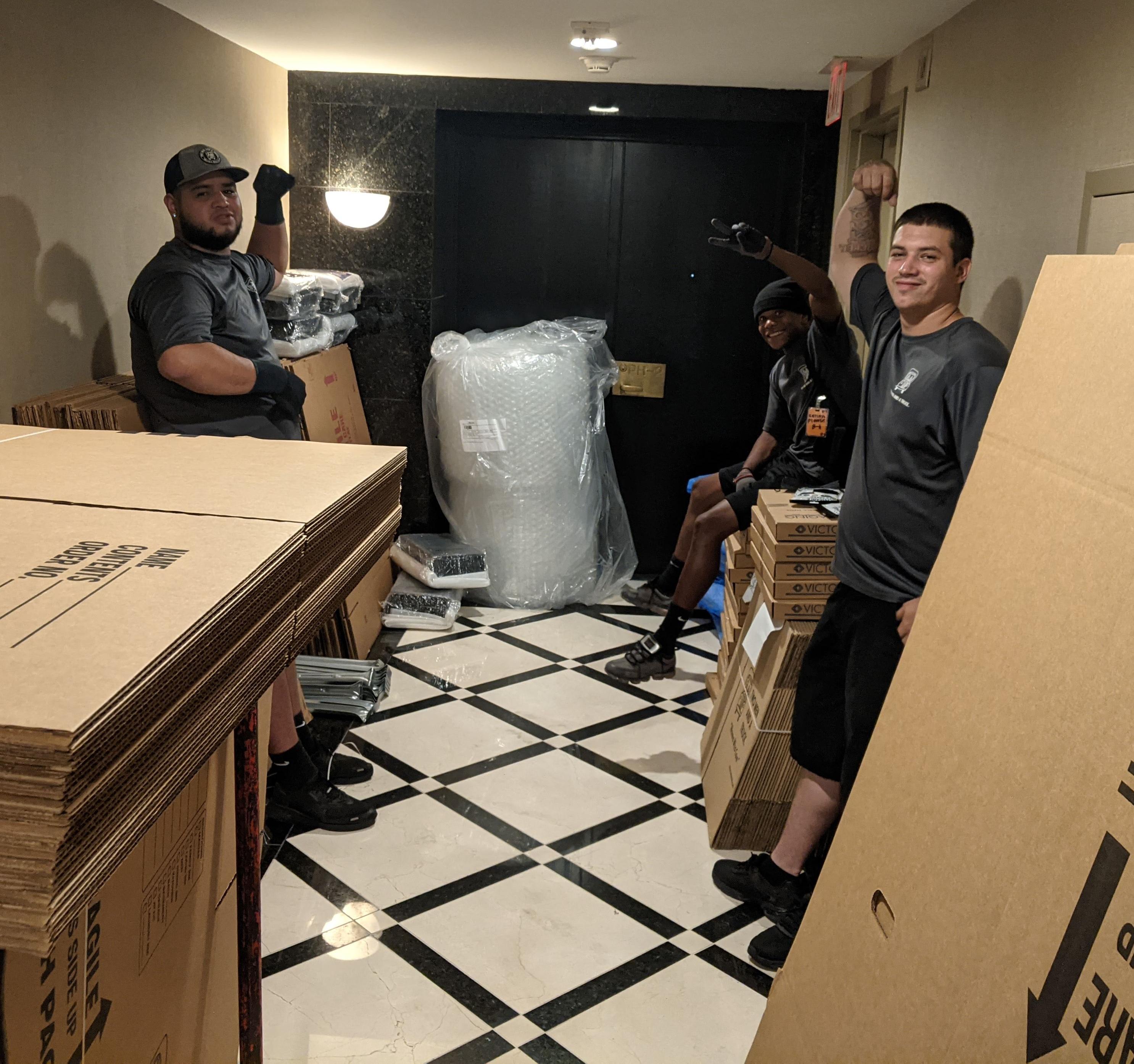 movers standing in a hallway with boxes surrounding them