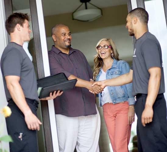 A couple welcoming the movers at the door