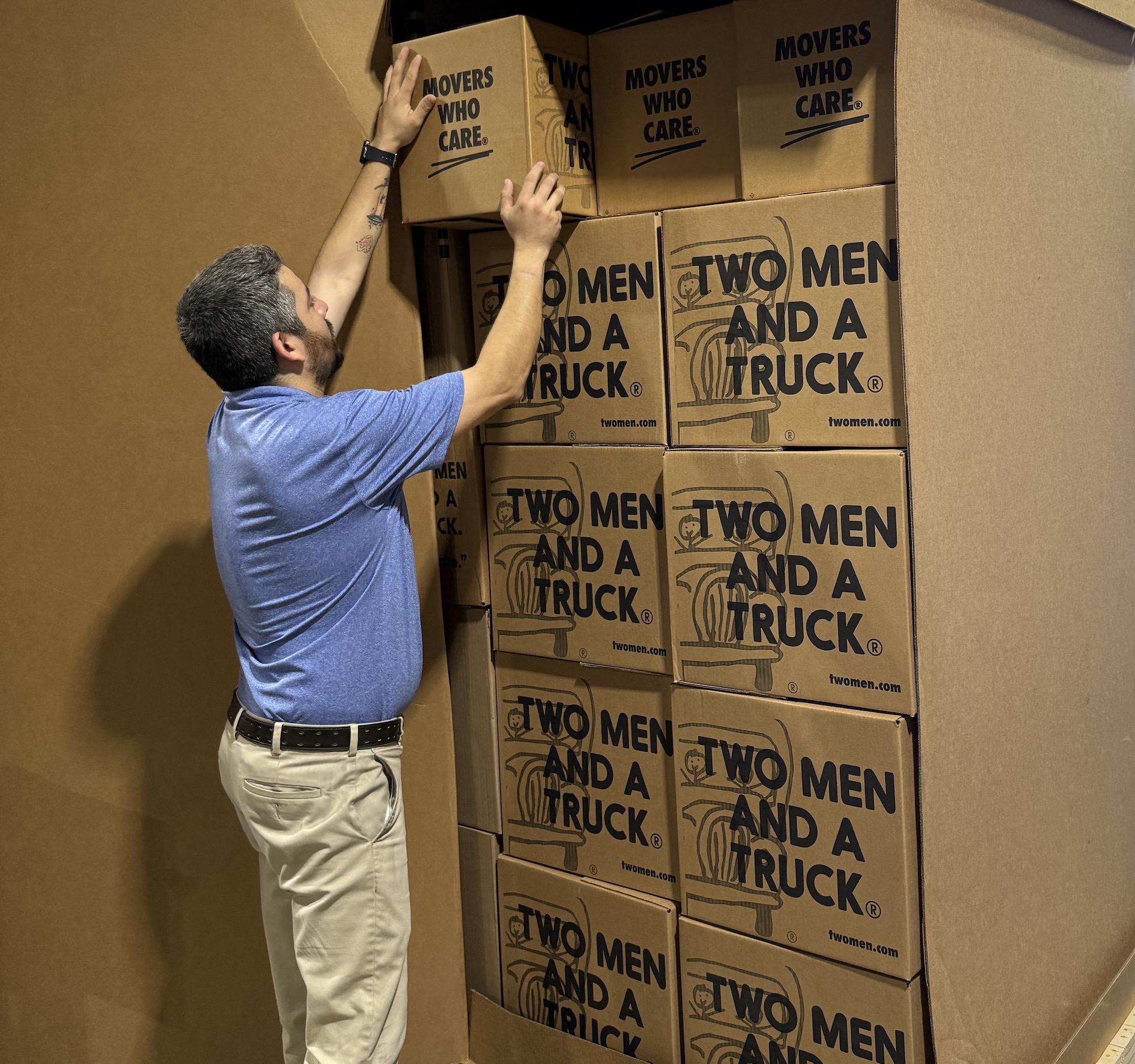 Image of a Two Men And A Truck employee stacking boxes in a value flex crate for a cost effective long distance move.