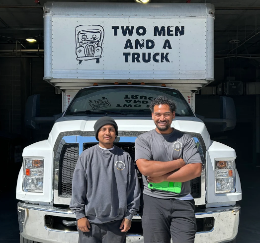 two movers are standing in front of a moving truck