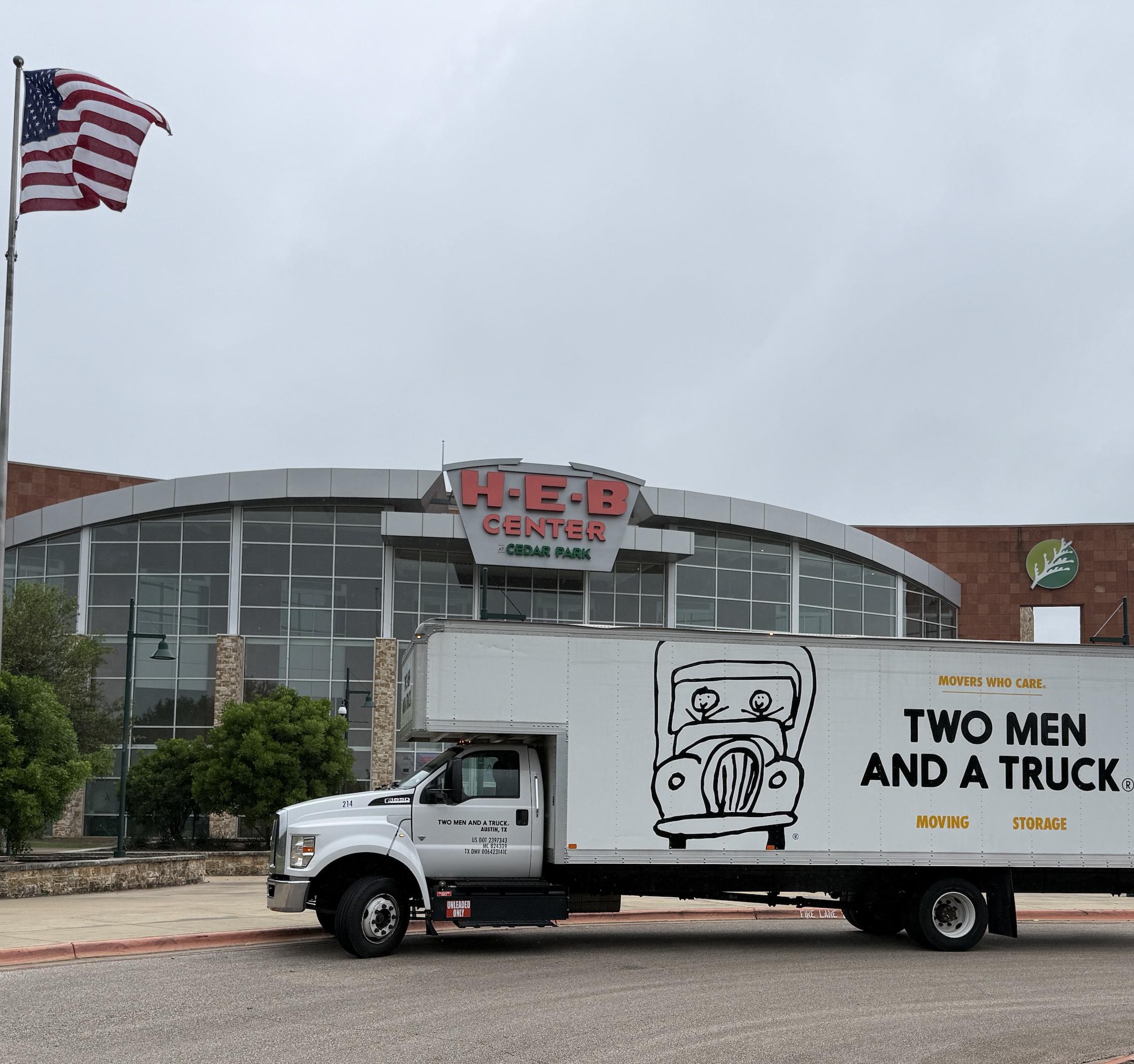 Image of a Two Men And A Truck moving truck parked in front of the HEB Center in Cedar Park Texas.