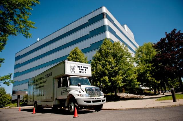 TWO MEN AND A TRUCK moving truck in front of a business complex