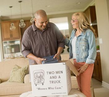 couple packing belongings in a two men and a truck moving box