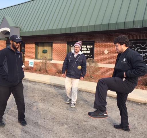 3 men playing hackey sack after work