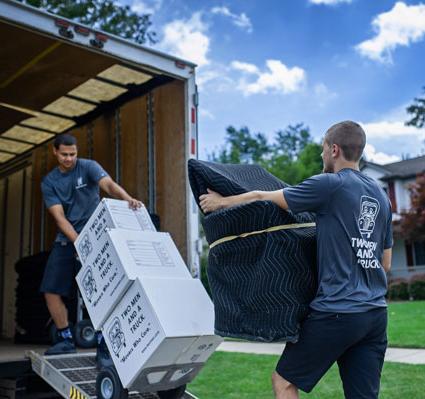 movers carrying items up a truck ramp