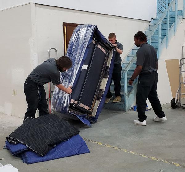 movers training on how to transport a mattress up stairs