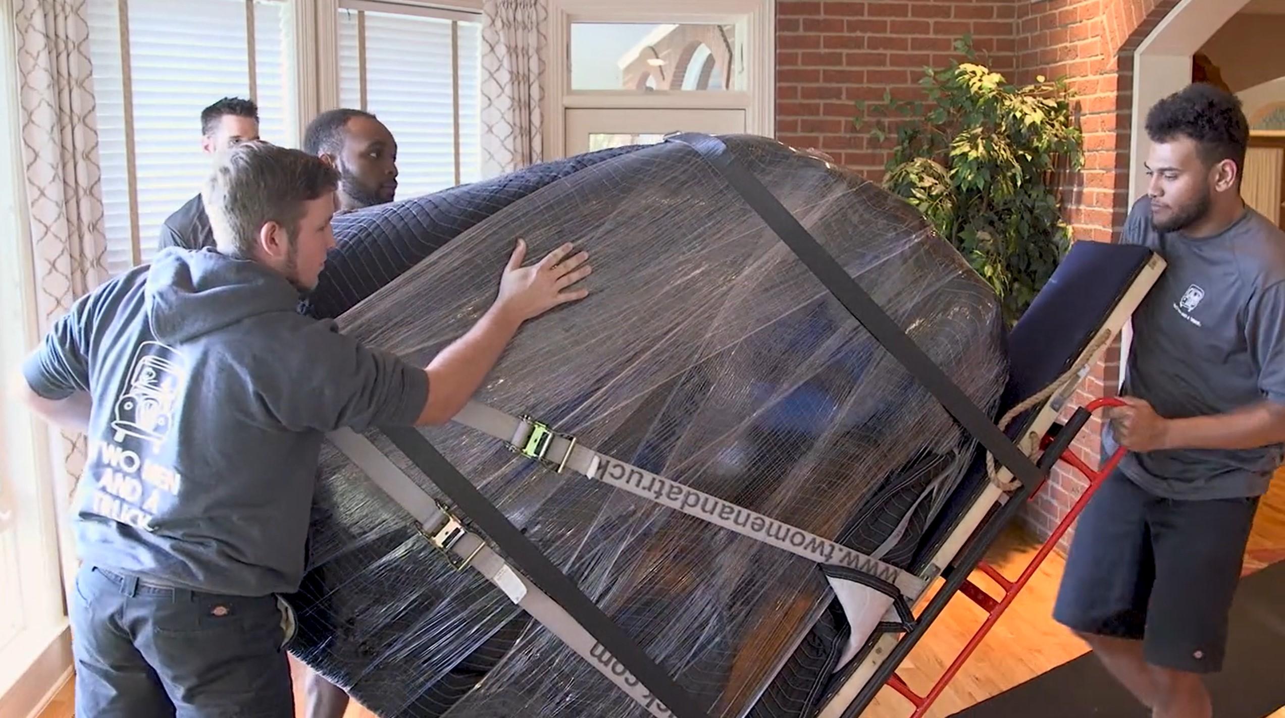 Movers moving a piano