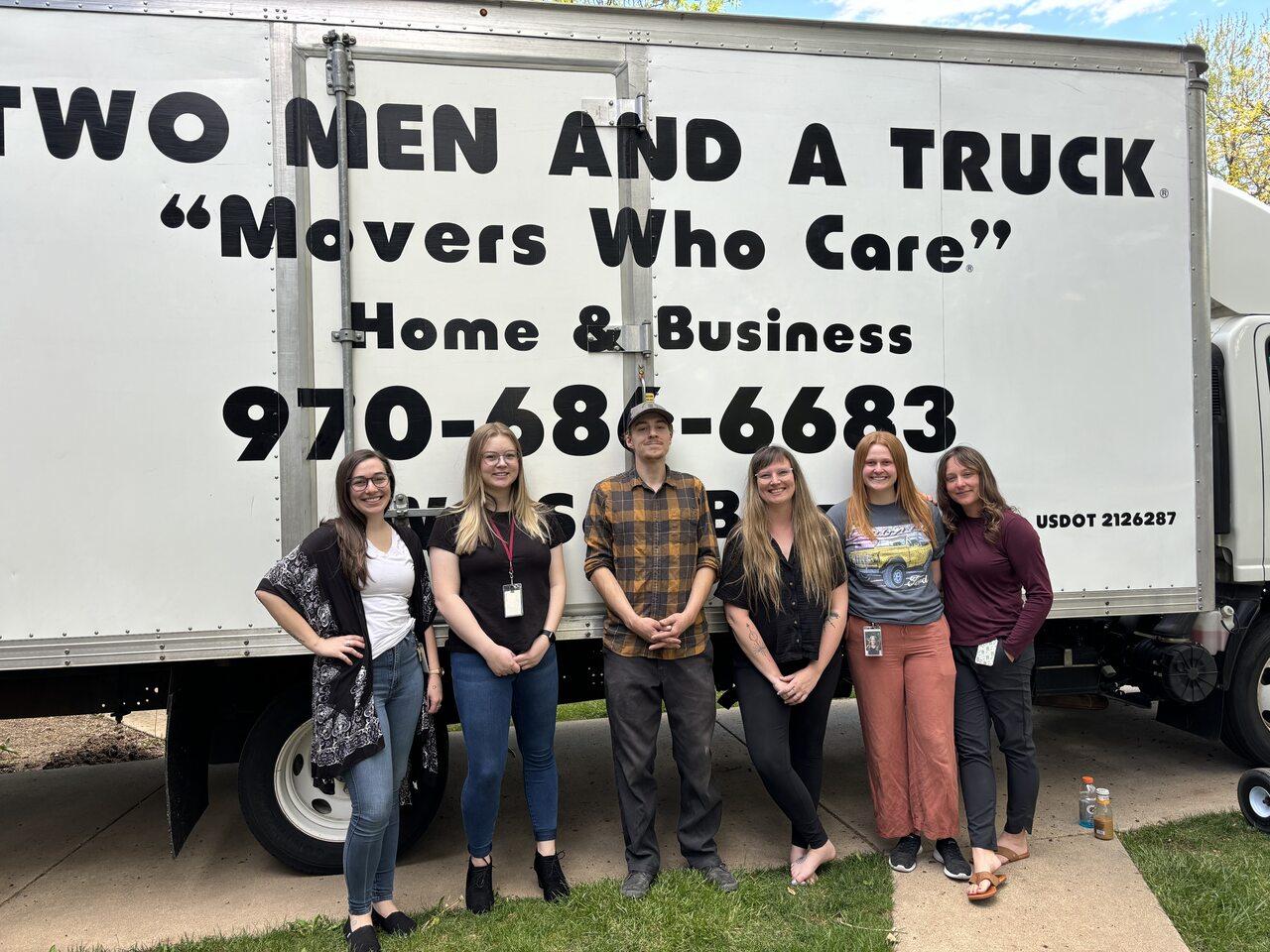 operations manager, will, is standing with employees from alternatives to violence in front of a moving truck