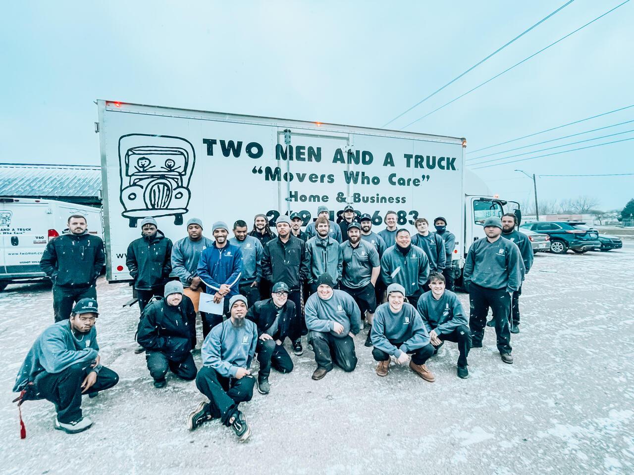 a group of movers in front of a truck smiling and laughing