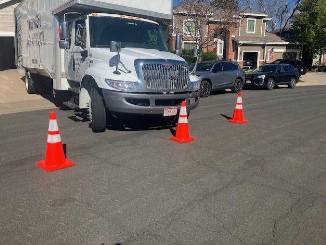 moving truck parked in a driveway with safety cones surrounding it