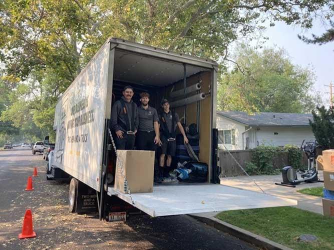 three movers in the back of a truck