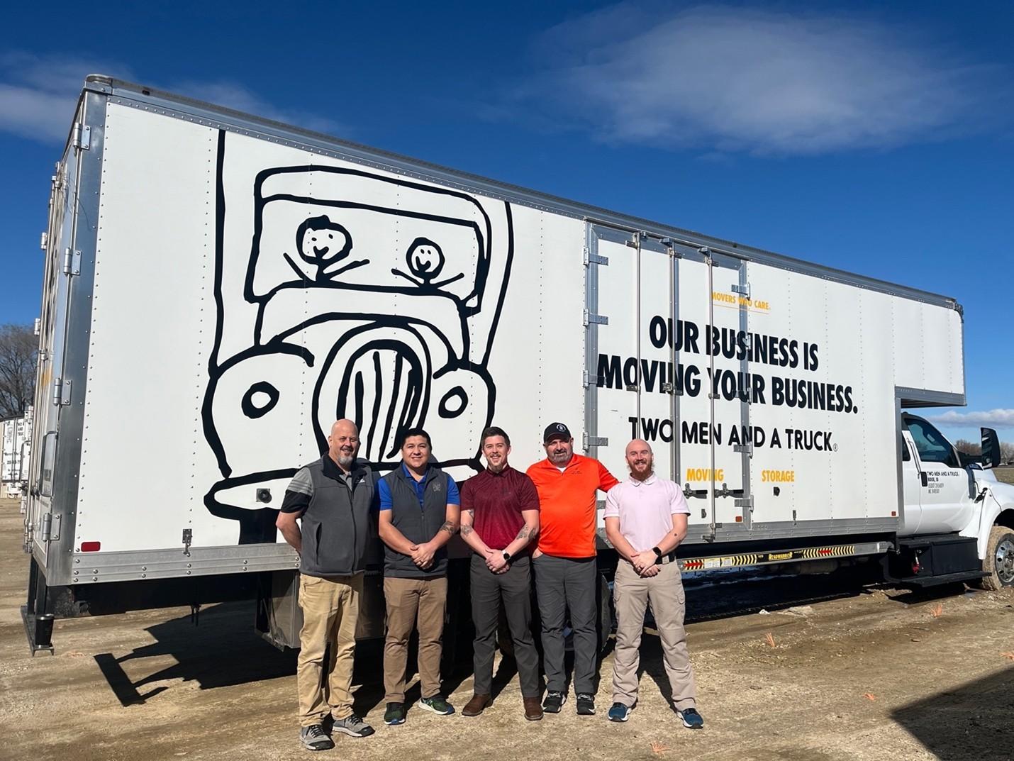 employees standing in front of a truck