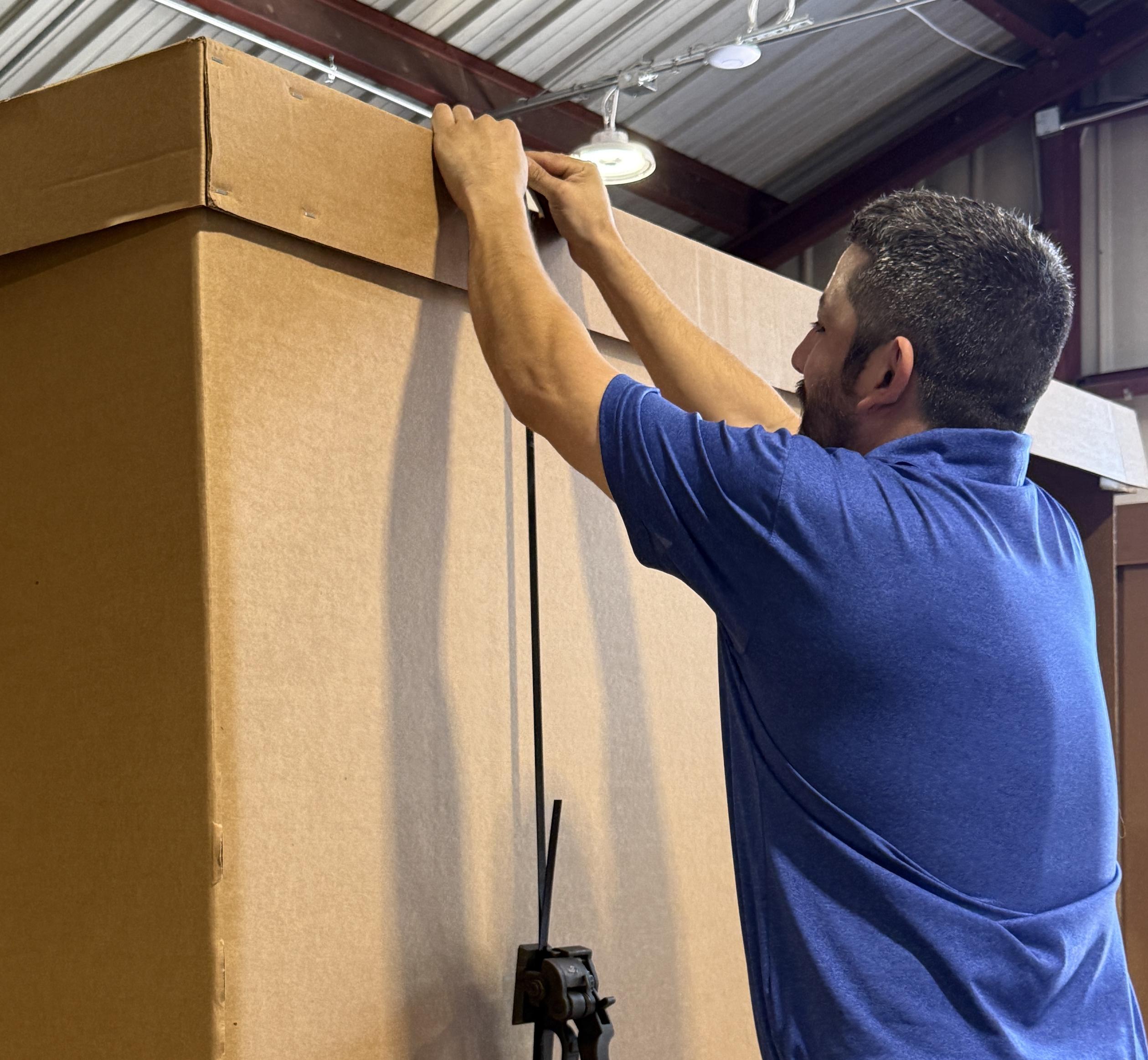 Mover sealing up a value flex crate on a long distance move
