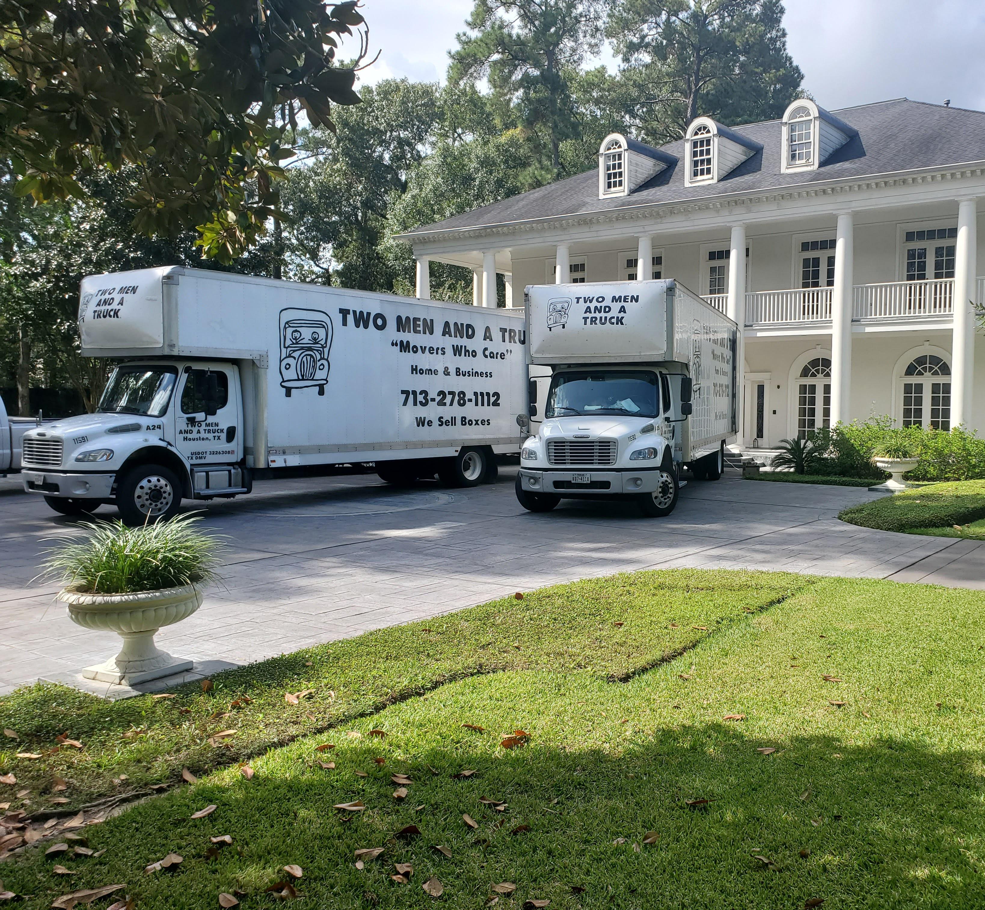 Two trucks in front of large house